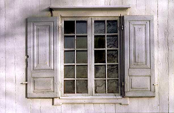 Småspröjsat fönster med munblåst glas och hörnjärn av 1700-talstyp.