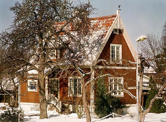Faluröd träpanel, vita knuta, tätspröjsade fönster och det branta takfallet är typiska nationalroman