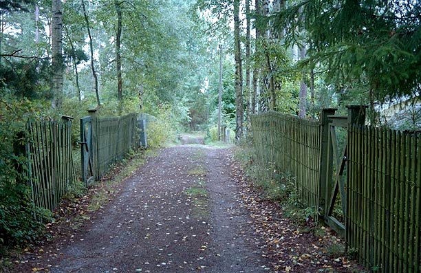 Grusväg som avgränsas med gröna staket och grindar, Årsta havsbad.